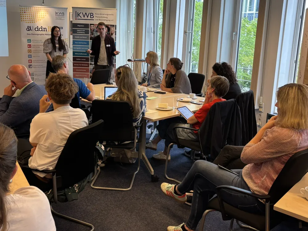 Foto von den Referierenden und dem Publikum.