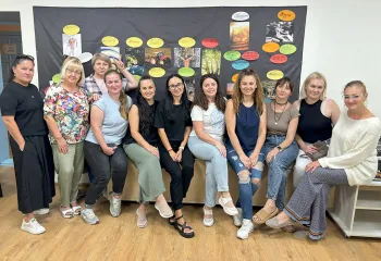 Frauen vor einer dunkel abgehängten Wand mit Fotos und Moderationskarten