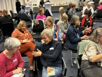Frauen arbeiten in Kleingruppen im Raum verteilt.