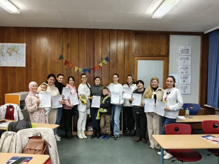 12 qualifizierte Elternmentoren/-innen zeigen freudig ihre Urkunden.