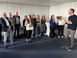 Dr. Oliver Borszik leitet Teilnehmende an, die hinter einer Linie stehen.