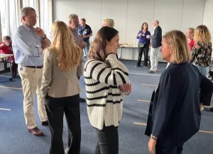 Teilnehmende stehen in kleinen Gruppen zusammen.